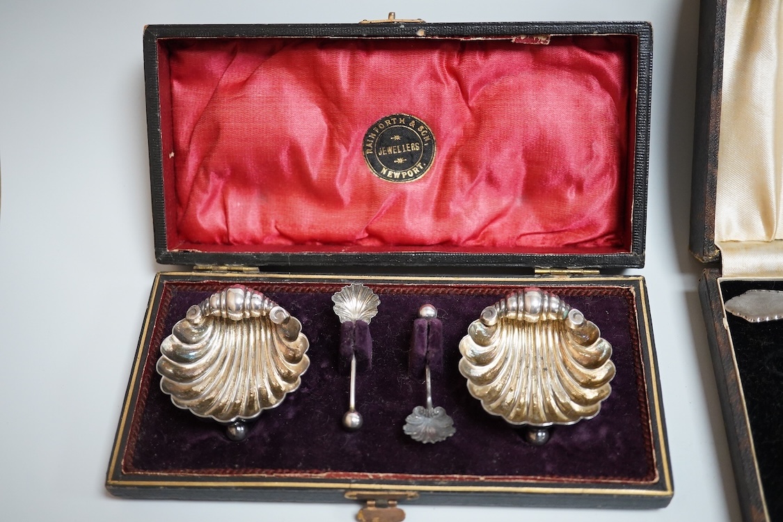 A cased pair of late Victorian silver shell salts on ball feet, with matching spoons, H. Bros, Birmingham, 1895, 46mm, together with a cased George V silver spoons and pusher and a Victorian silver shoe buckle (a.f.)